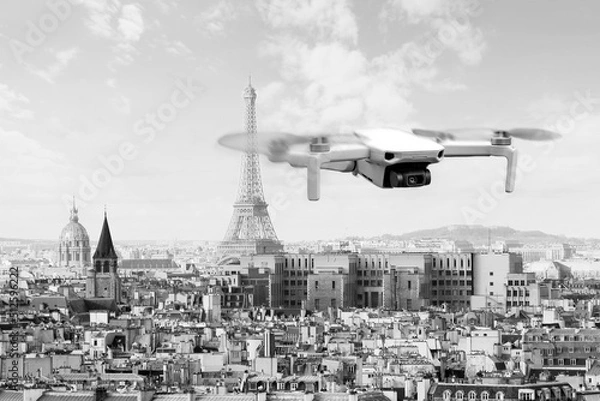 Fototapeta Drone with 4k digital camera flying over Paris city with Eiffel tower at the background in Paris, France. Technology background