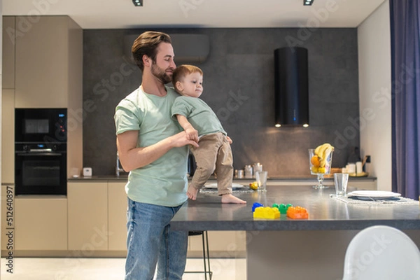 Fototapeta Dad and son looking happy spending time together