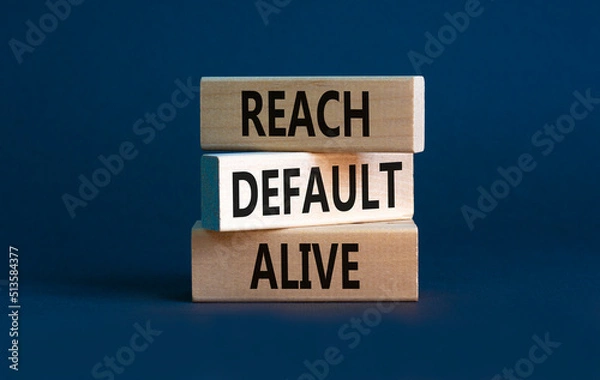 Fototapeta Reach default alive symbol. Concept words Reach default alive on wooden blocks on a beautiful grey table grey background. Business, finacial and reach default alive concept. Copy space.