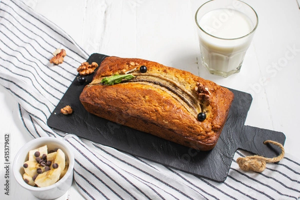 Obraz Banana bread or cake on white wooden table. Delicious homemade dessert, tasty snack or morning breakfast