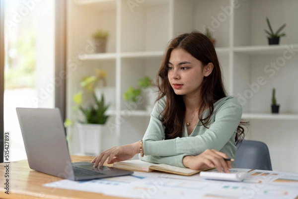 Fototapeta Young accountant freelance working in office using laptop with calculator. concept business finance and accounting, tax, debt concept