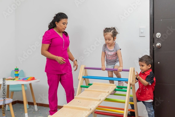 Fototapeta Female doctor giving consultation to two children in the games room of her office