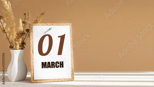 Fototapeta march 1. 1th day of month, calendar date.White vase with dead wood next to cork board with numbers. White-beige background with striped shadow. Concept of day of year, time planner, spring month