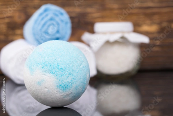 Fototapeta close-up of a ball of salt on a dark wooden background and towels for spa treatments wrapped in a roll