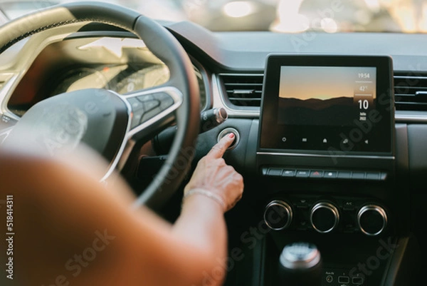 Fototapeta woman pressing the automatic start button on her car