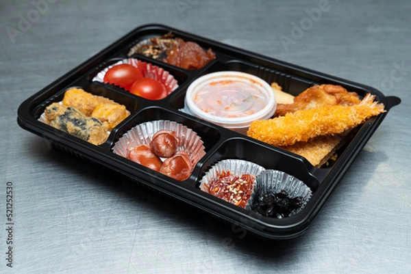 Fototapeta A delicious-looking lunch box with a variety of side dishes, fruits and tempura