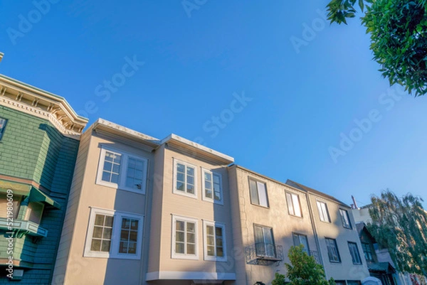 Fototapeta Townhouses in a low angle view at the neighborhood of San Francisco, California