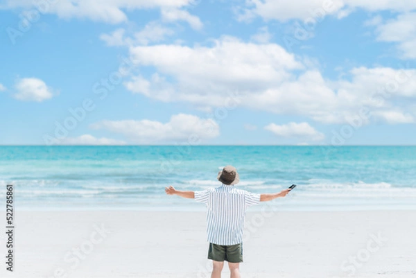 Fototapeta freedom life, happy on holiday, alone traveler, work life balance, a man standing on the beach, freelance lifestyle, relaxing on vacation