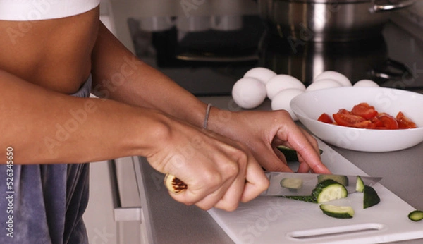 Fototapeta Human hands cooking vegetables salad in kitchen.