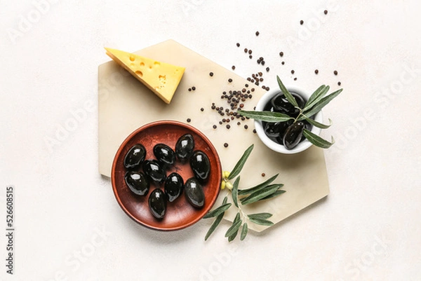 Fototapeta Composition with bowls of tasty black olives, cheese and spices on light background