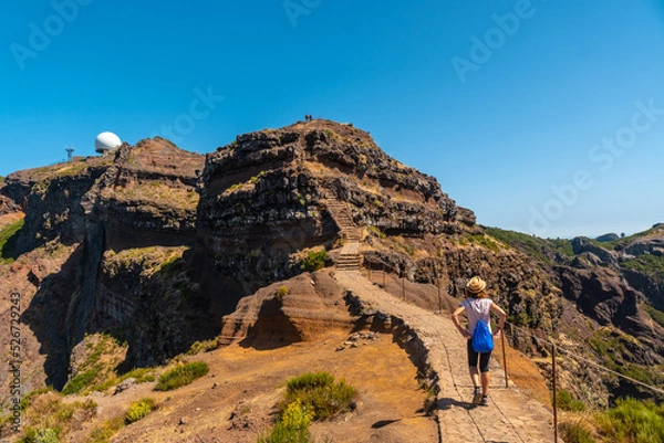 Fototapeta A young tourist on the trail to Pico do Arieiro from Ninho da Manta viewpoint, Madeira. Portugal