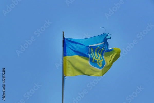 Fototapeta worn ukraine flag waving on blue sky