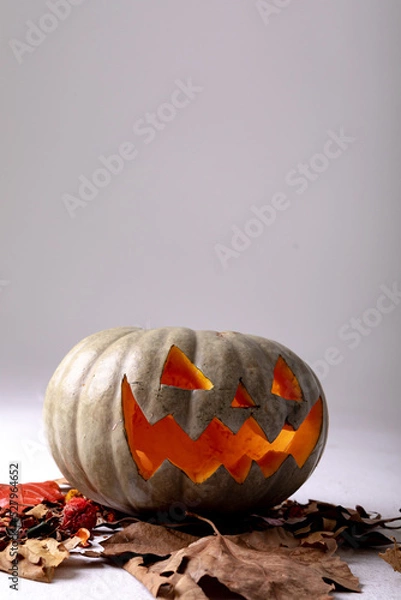 Obraz Composition of halloween jack o lantern, leaves and copy space on grey background