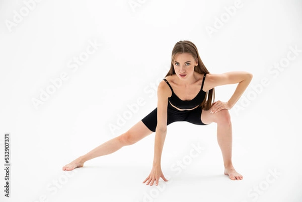 Fototapeta Beautiful brunette fitness woman doing yoga on a white background