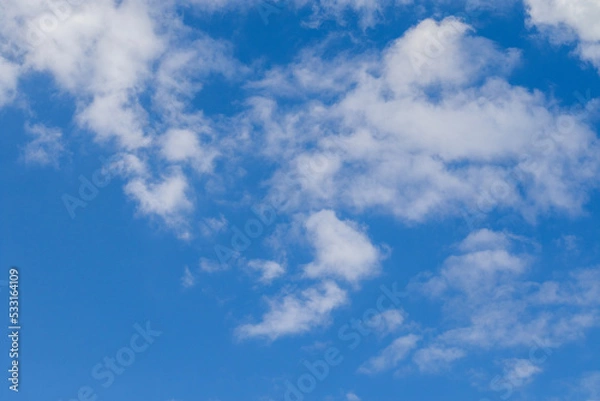 Fototapeta Leichte weiße Schleierwolken vor blauem Himmel an einem sonnigen Tag im Sommer