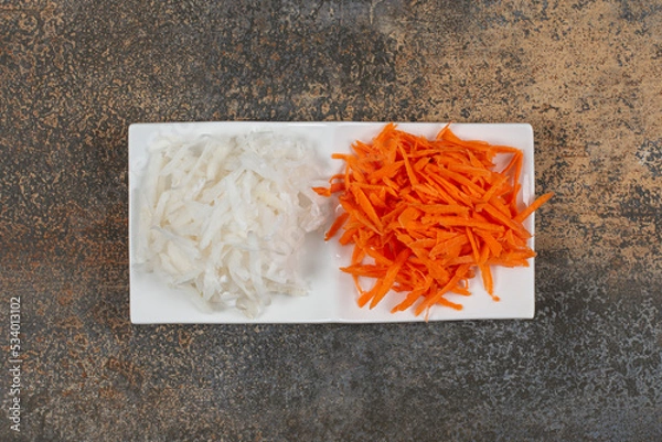 Obraz Shredded white cabbage and pepper on white plate