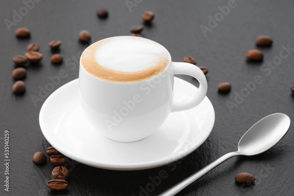 Obraz Cappuccino White cup on a black background. Coffee with milk on black coffee beans. Coffee on a black background.