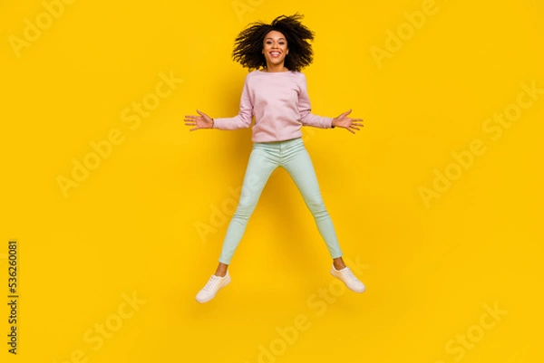 Fototapeta Full length photo of young pretty woman have fun jump up carefree isolated over yellow color background