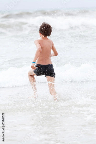 Fototapeta kleiner junge spiel glücklich im sand am meer im wasser