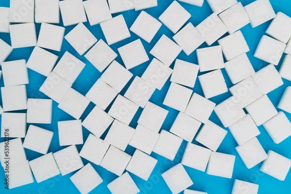 Fototapeta Sugar cubes on blue background