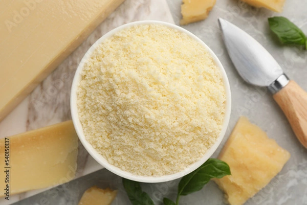 Fototapeta Flat lay composition with grated parmesan cheese, basil and knife on grey table