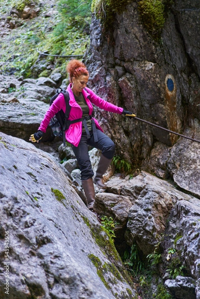 Obraz Woman hiking on a trail in the mountains