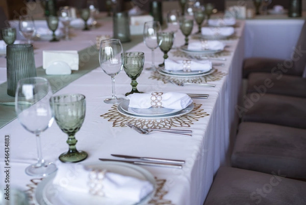 Fototapeta 
Serving and decoration of the wedding table. Glasses, spoons, forks and white napkins