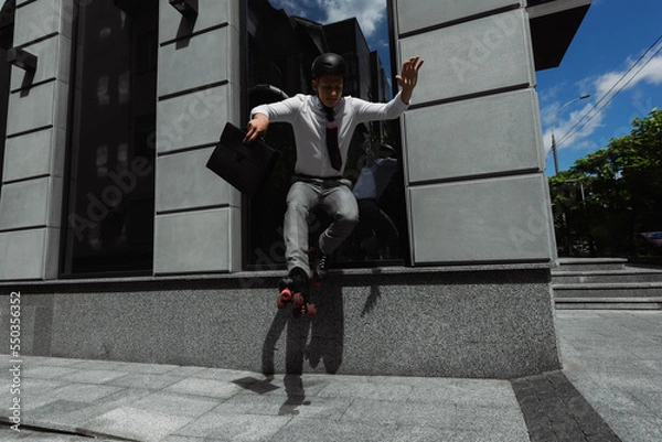 Fototapeta Young businessman in roller skates holding briefcase and doing trick on urban street.