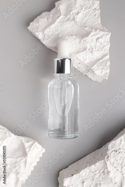 Fototapeta Cosmetic bottle with dropper pipette with serum on concrete plate for product presentation. Skin care cosmetic. Beauty concept for face body care