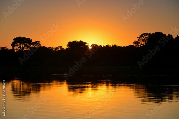 Fototapeta Sunrise on the rainforest-lined Guaporé-Itenez river near the remote village of Remanso, Beni Department, Bolivia, on the border with Rondonia state, Brazil