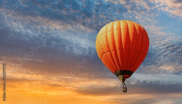 Fototapeta Orange hot air balloon against the backdrop of an expressive sunset sky