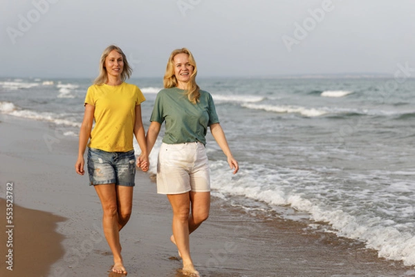 Fototapeta Girlfriends walk and have fun at the sea, family vacation at sea