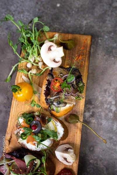 Obraz top view assorted bruschetta with different flavors on a wooden board