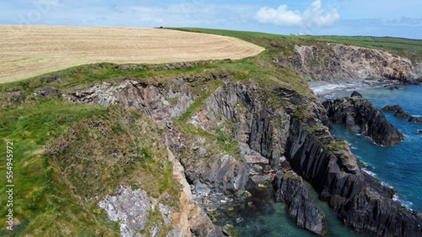 Fototapeta Farm fields on the shore of the Celtic Sea, south of Ireland, County Cork. Beautiful coastal area. Turquoise waters of the Atlantic. Picturesque stone hills. View from above.