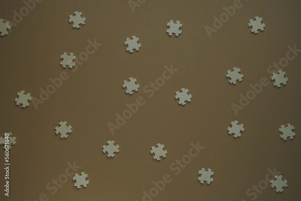 Fototapeta Flat blank wooden puzzles on brown background view from above. Festive background for a congratulatory inscription. New Year, Christmas, Valentine, Birthday. Blurred background