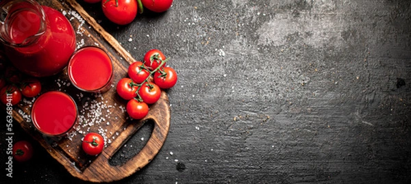 Fototapeta Glasses of tomato juice on a cutting board. 