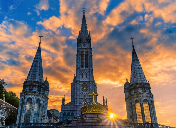 Fototapeta The sun star among the bell towers of the pilgrimage basilica of the apparitions of Mary in Lourdes