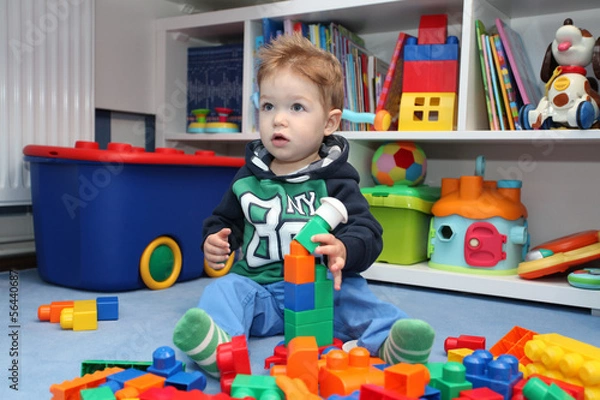 Fototapeta A baby boy playing with plastic blocks