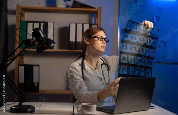 Fototapeta Doctor examine MRI picture working at night. Medical test with x-ray.