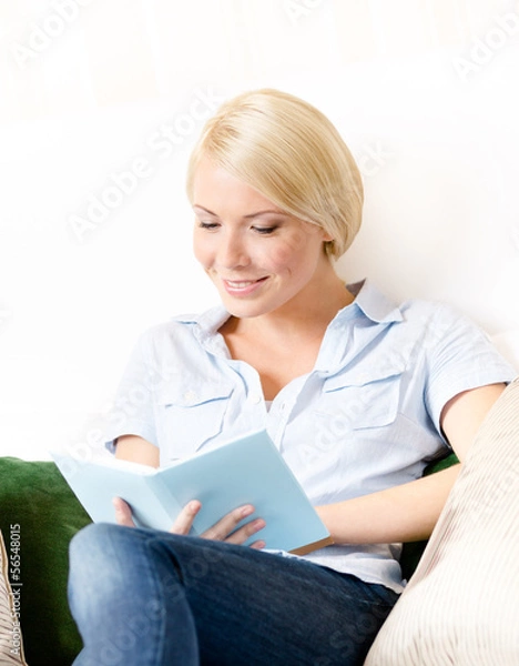 Fototapeta Lady sitting on the couch reads a book