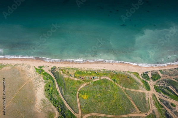 Fototapeta aerial view of the sea coast with green vegetation in the foreground on the shore