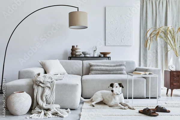 Fototapeta Stylish composition of cozy living room interior design with mock up structure painting, dog, corner sofa, coffee table, textile and personal accessories. Scandinavian classic style.