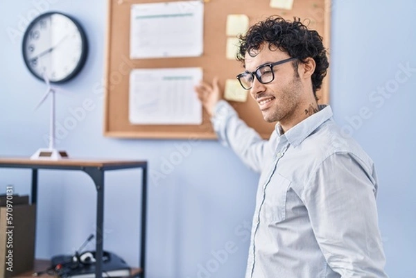 Fototapeta Young hispanic man business worker speaking at office