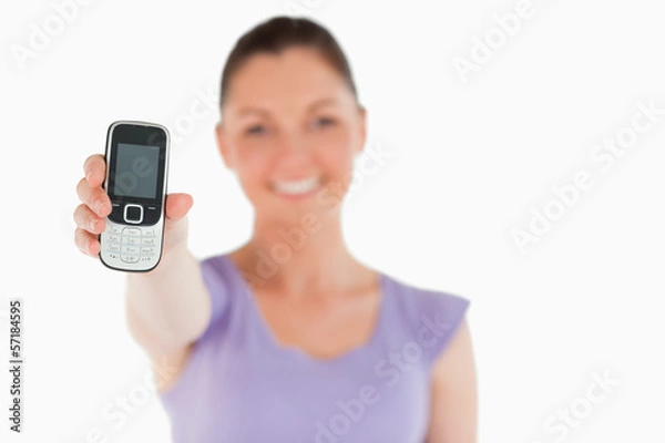 Fototapeta Attractive woman holding and showing her phone while standing