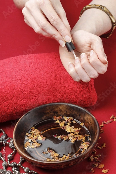 Fototapeta Woman in a nail salon receiving a manicure