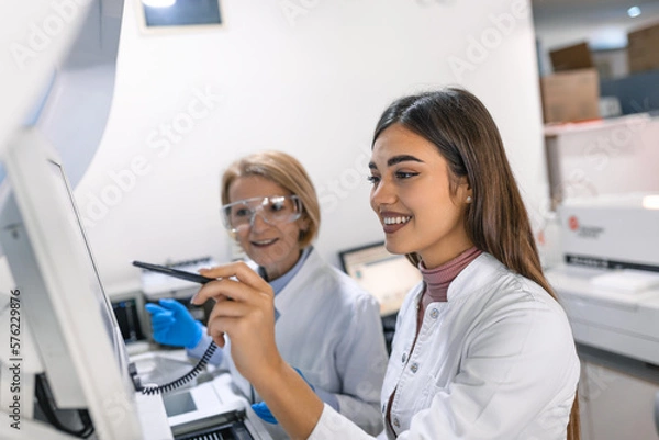 Fototapeta Two Research Scientists Talking about Programming Medical Equipment for Tests. Team of Professionals Doing Pharmaceutical Research in Modern Laboratory