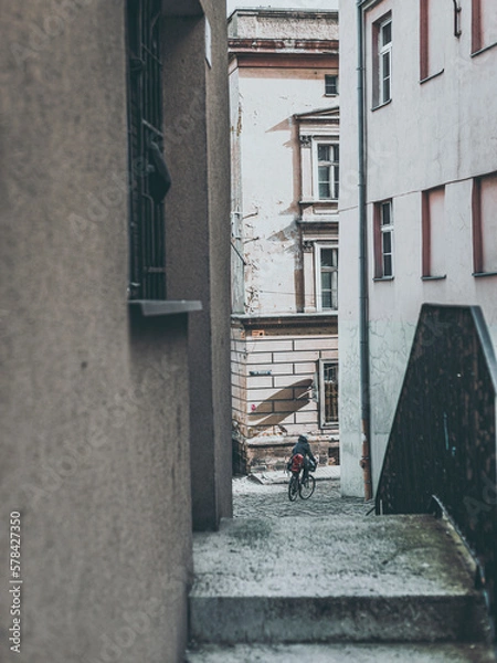 Obraz passage between tenement houses with person on bike