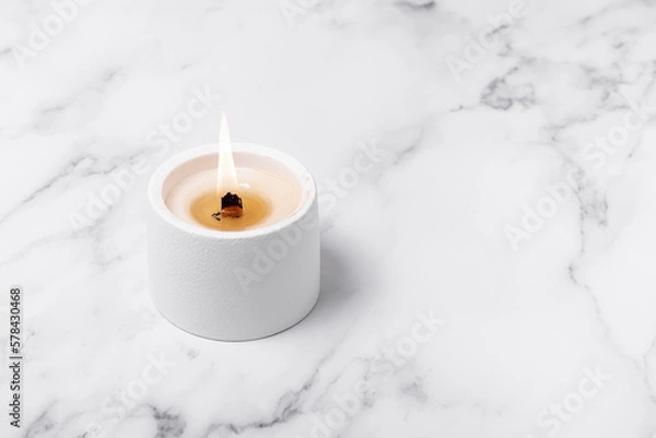 Fototapeta Handmade soy wax candle on marble background. Crackling wick. Space for text 