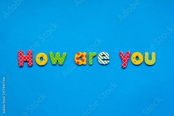 Fototapeta text how are you from bright colored paper letters on blue paper background