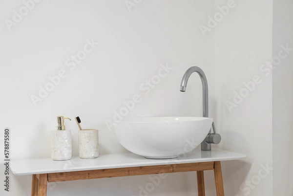 Fototapeta Sink with soap bottle and toothbrush on table in light bathroom